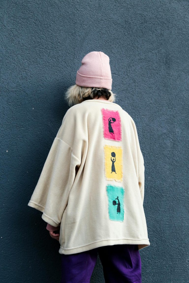 Person in a stylish outfit with graphic details standing outdoors.