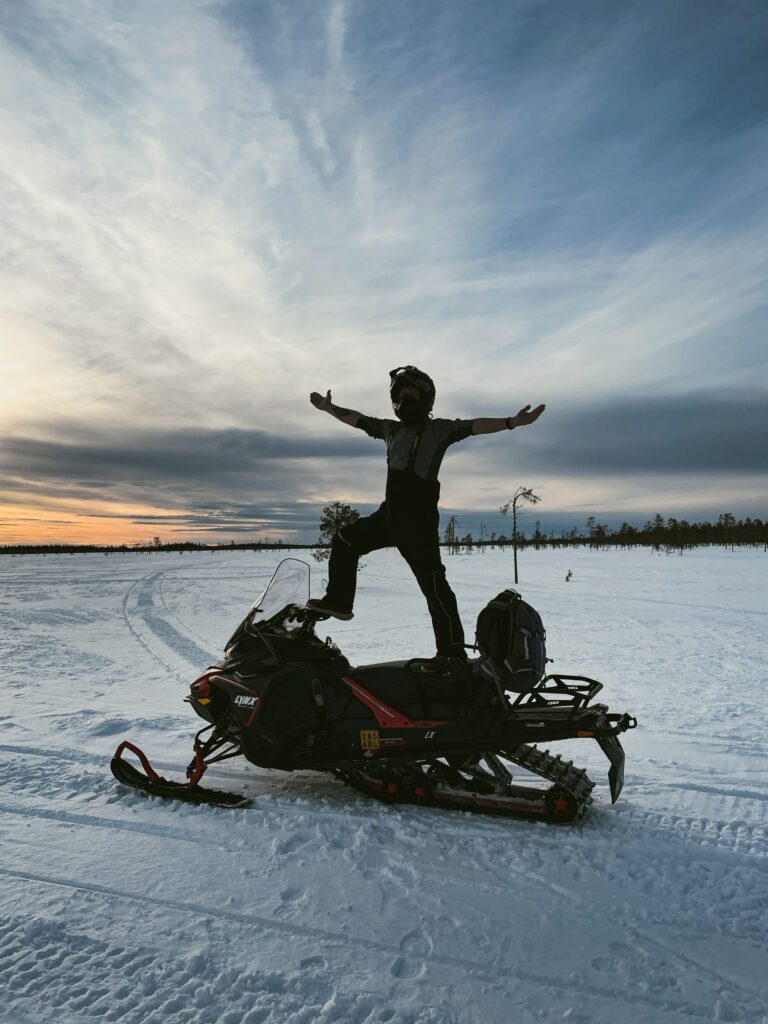 Lapland wilderness on a snowmobile - inspiration behind Konna Clothing’s sustainable mission.